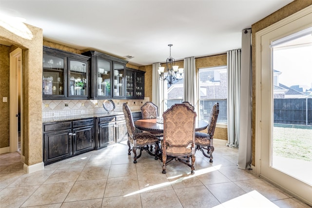 dining room with light tile patterned floors and a chandelier