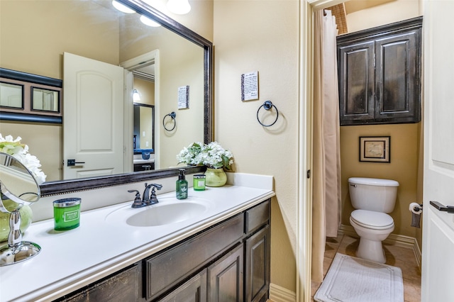 bathroom featuring vanity, tile patterned floors, and toilet