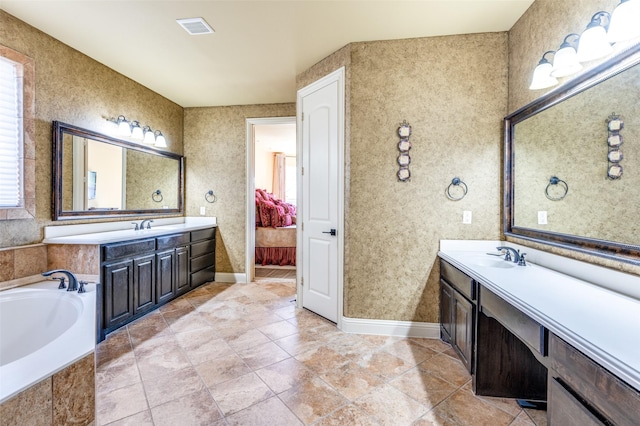 bathroom featuring vanity, tile patterned flooring, and tiled tub