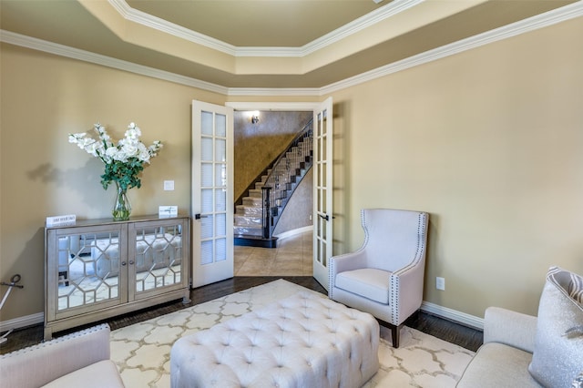 sitting room featuring french doors, a tray ceiling, and hardwood / wood-style floors