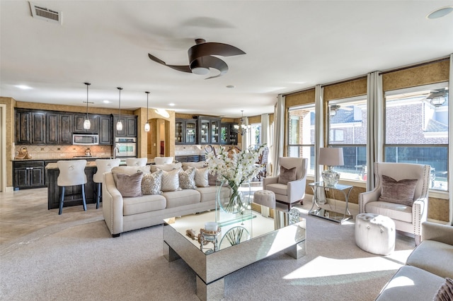 living room featuring ceiling fan with notable chandelier