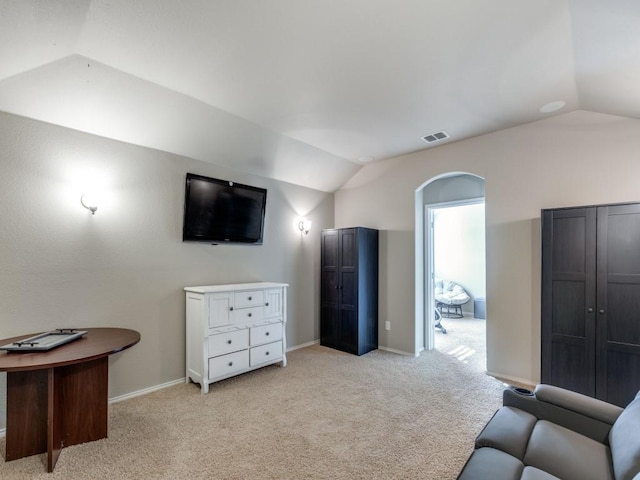 interior space featuring vaulted ceiling and light carpet