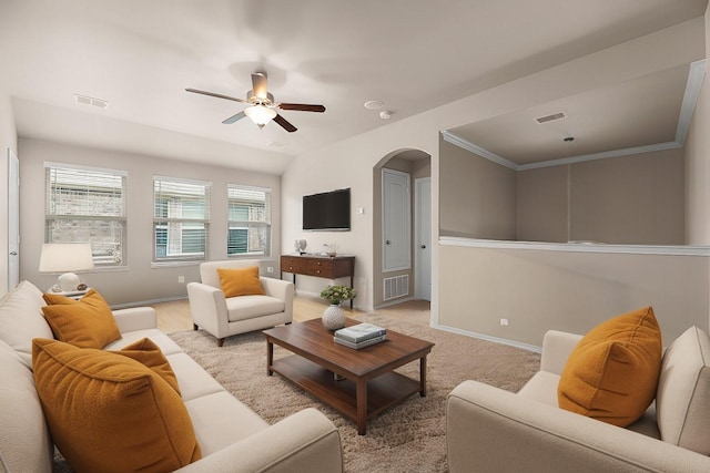 living room featuring baseboards, visible vents, arched walkways, and ceiling fan