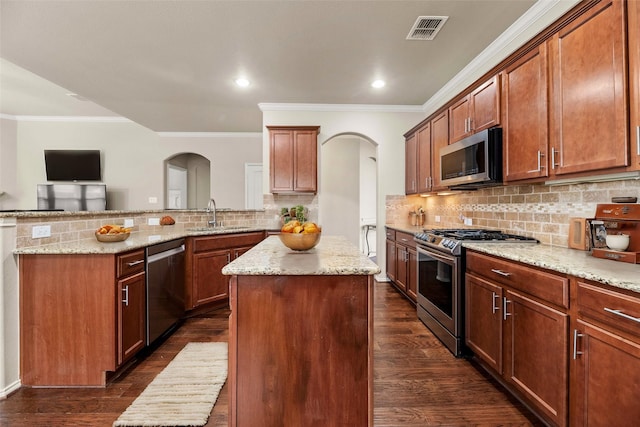 kitchen featuring visible vents, arched walkways, appliances with stainless steel finishes, and a sink