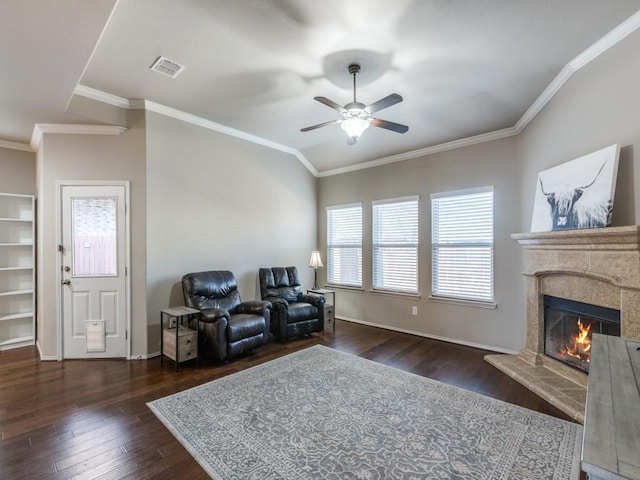 living area with a premium fireplace, dark hardwood / wood-style floors, ceiling fan, and crown molding