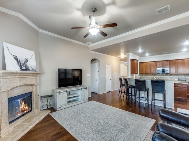 living room featuring a fireplace, ornamental molding, and dark hardwood / wood-style floors