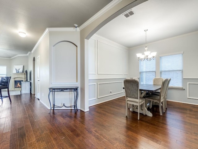 dining room with ornamental molding, dark hardwood / wood-style floors, and a chandelier