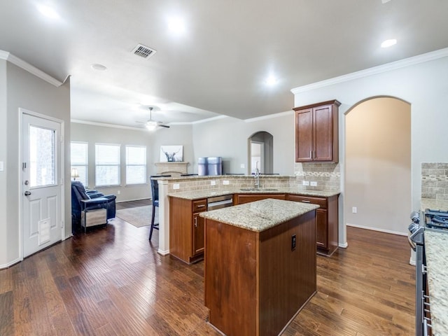 kitchen with backsplash, a center island, kitchen peninsula, stainless steel appliances, and dark wood-type flooring