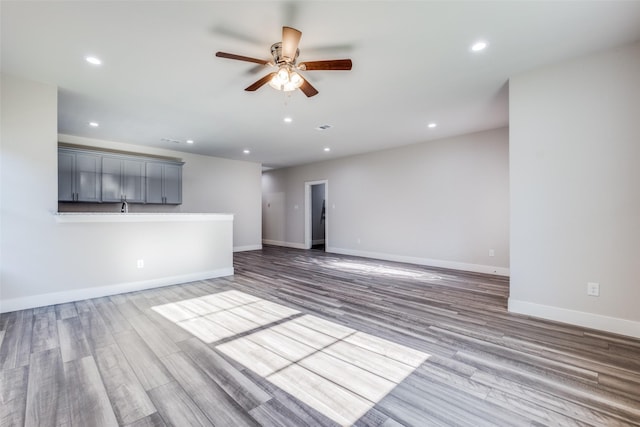 unfurnished living room with hardwood / wood-style flooring and ceiling fan