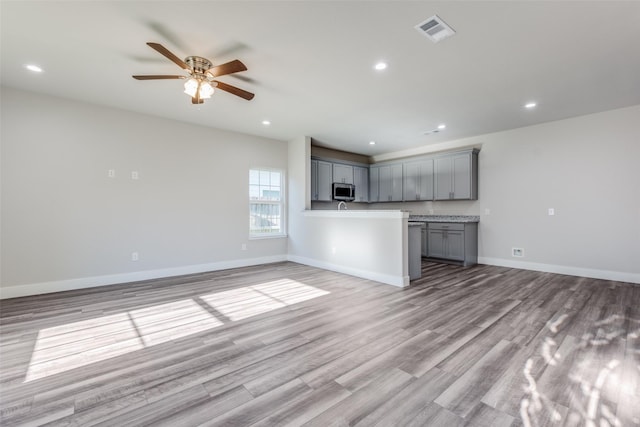 unfurnished living room with ceiling fan and light hardwood / wood-style floors