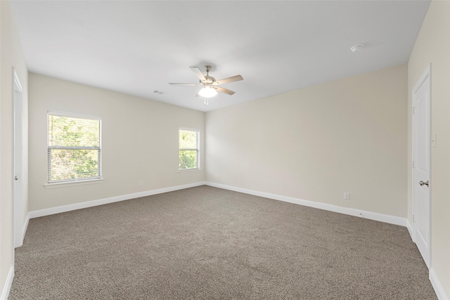 carpeted spare room featuring ceiling fan