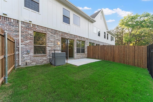 back of house with a patio area and a lawn