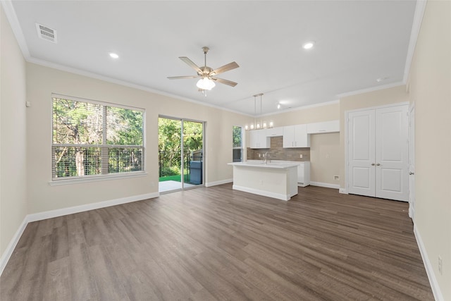 unfurnished living room with dark hardwood / wood-style flooring, sink, ornamental molding, and ceiling fan