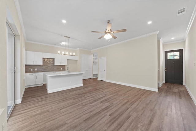 unfurnished living room with crown molding, ceiling fan, sink, and light hardwood / wood-style flooring