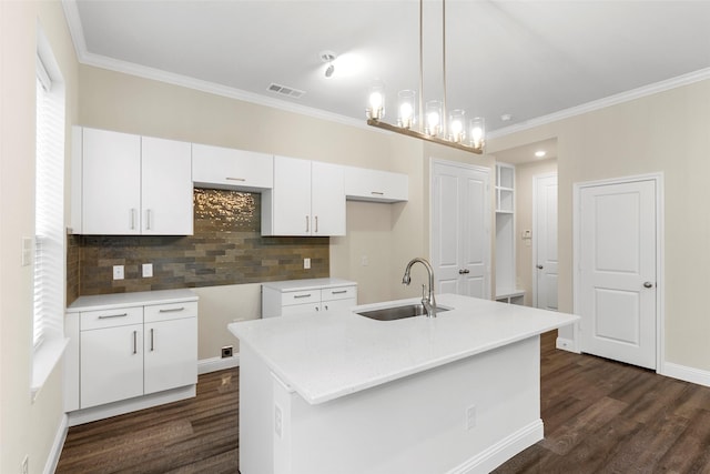 kitchen with sink, dark hardwood / wood-style floors, an island with sink, white cabinets, and decorative light fixtures