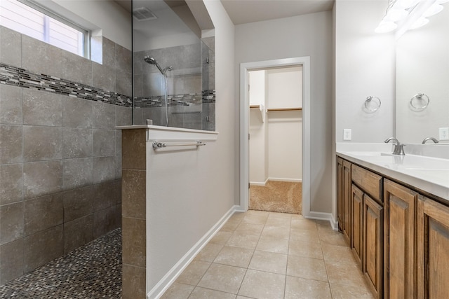 bathroom with vanity, tile patterned flooring, and tiled shower