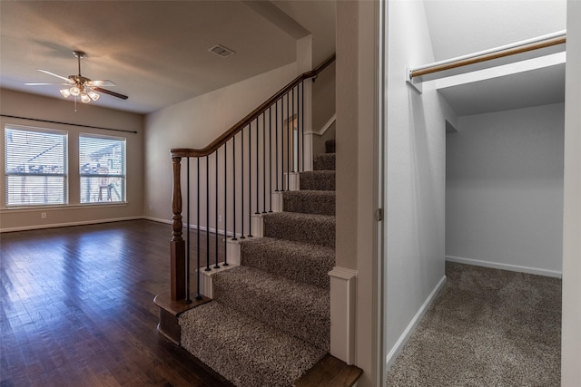 staircase with wood-type flooring and ceiling fan