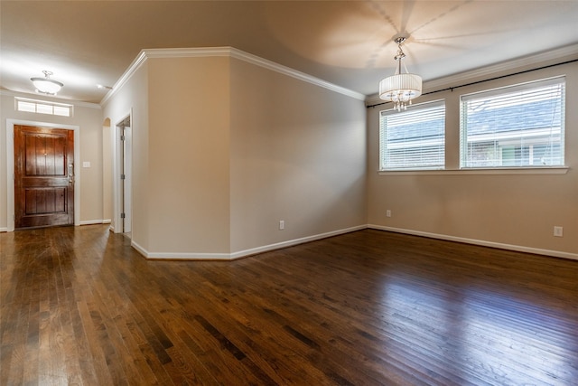 unfurnished room featuring an inviting chandelier, ornamental molding, and dark hardwood / wood-style floors