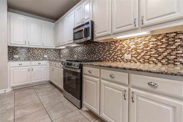 kitchen with appliances with stainless steel finishes, decorative backsplash, and white cabinets