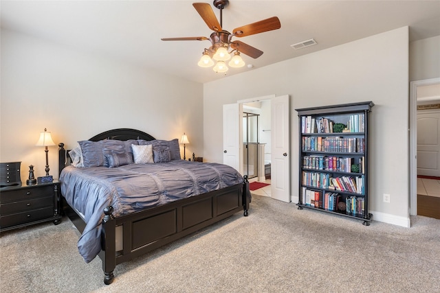 bedroom featuring light carpet, connected bathroom, and ceiling fan