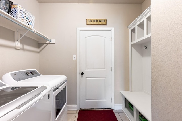 washroom with light tile patterned flooring and washer and dryer