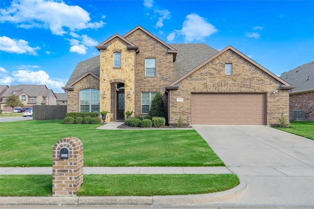 front of property with a garage, cooling unit, and a front lawn