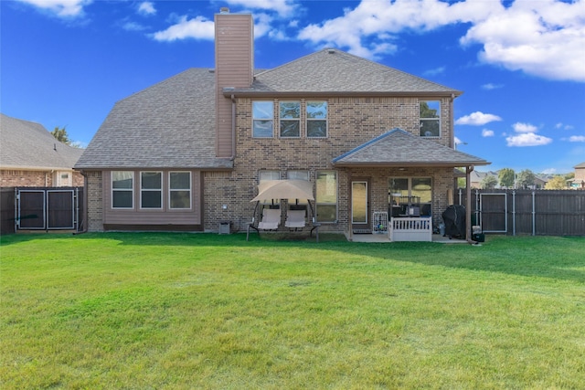 rear view of property featuring a patio area and a lawn