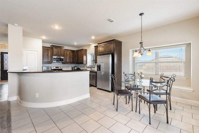 kitchen featuring sink, stainless steel appliances, dark brown cabinetry, light tile patterned flooring, and decorative light fixtures