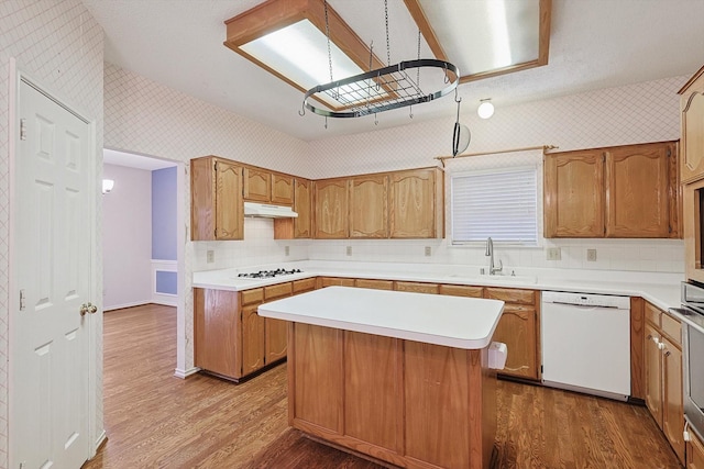 kitchen featuring a kitchen island, sink, backsplash, dark hardwood / wood-style flooring, and white appliances