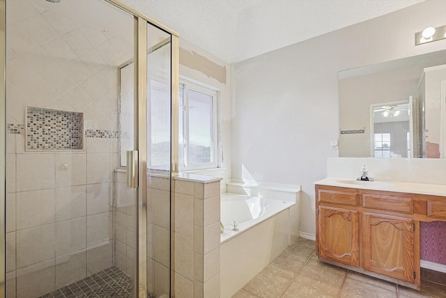 bathroom with tile patterned flooring, vanity, separate shower and tub, and a textured ceiling