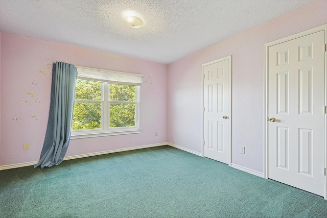 unfurnished bedroom featuring a textured ceiling and dark colored carpet