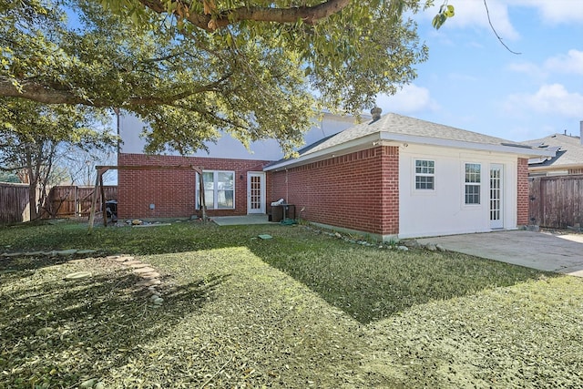 rear view of property featuring a yard and a patio area