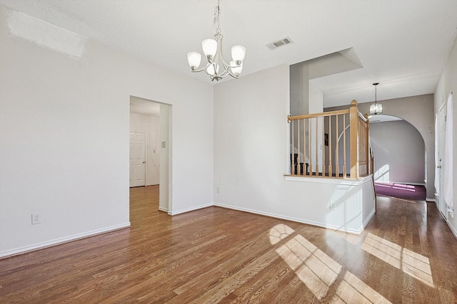 unfurnished room featuring dark hardwood / wood-style floors and a notable chandelier