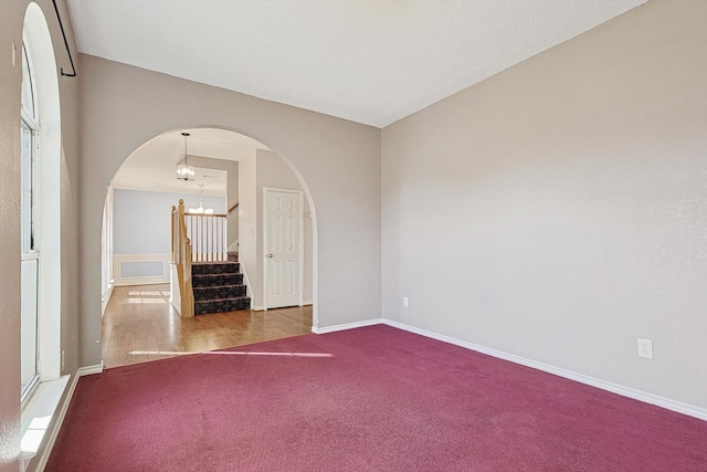 carpeted spare room with a chandelier