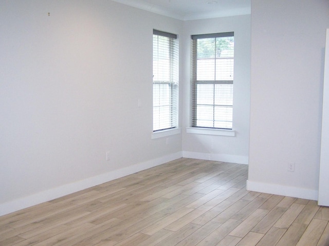 unfurnished room featuring ornamental molding and light hardwood / wood-style floors