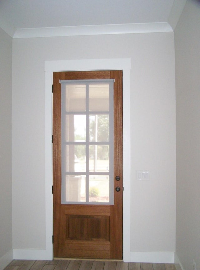 doorway featuring crown molding and wood-type flooring