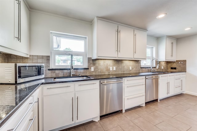 kitchen with stainless steel appliances, white cabinetry, and a sink