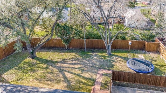 view of yard with a fenced backyard and a trampoline