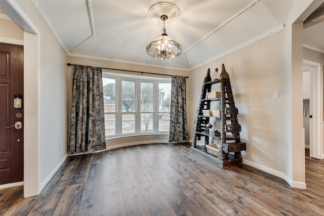 foyer featuring hardwood / wood-style floors, crown molding, and a chandelier