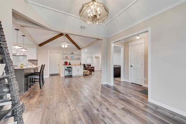 interior space featuring bar, hardwood / wood-style floors, wine cooler, lofted ceiling with beams, and ceiling fan with notable chandelier