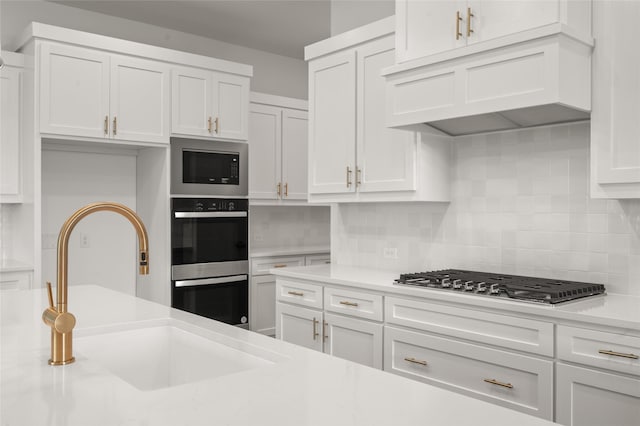 2301 Hawk Meadow Ct, Mansfield, TX 76063 - kitchen featuring stainless steel appliances, custom exhaust hood, white cabinets, light countertops, and tasteful backsplash