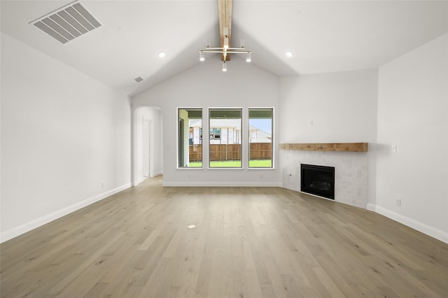 2301 Hawk Meadow Ct, Mansfield, TX 76063 - unfurnished living room featuring a tiled fireplace, beam ceiling, light wood-style flooring, high vaulted ceiling, and recessed lighting