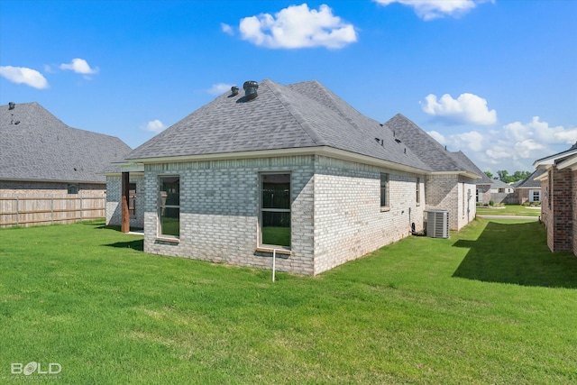 back of property featuring a lawn and central air condition unit