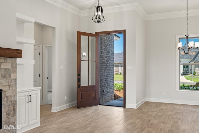 entrance foyer with crown molding, a healthy amount of sunlight, light wood-type flooring, and a notable chandelier