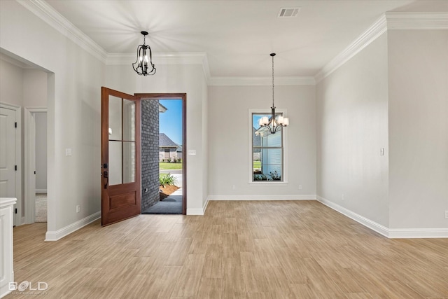 entrance foyer with ornamental molding, a notable chandelier, and light hardwood / wood-style floors