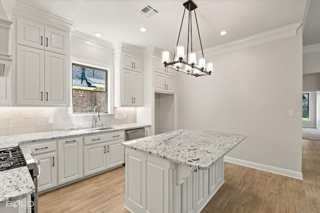 kitchen with a kitchen island, decorative light fixtures, white cabinetry, backsplash, and light stone counters