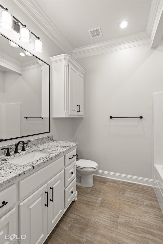 bathroom with ornamental molding, toilet, wood-type flooring, and vanity