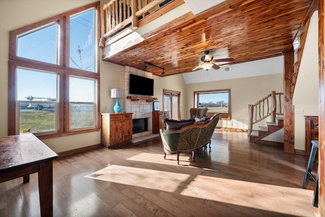 living room featuring baseboards, wood ceiling, stairway, hardwood / wood-style floors, and a fireplace