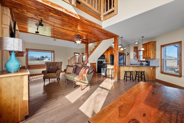 living room with hardwood / wood-style flooring, wood ceiling, stairs, and baseboards