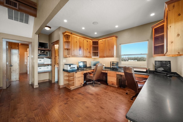 office with dark wood-type flooring and built in desk